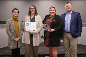 Board President Kate Parks and Superintendent Amy Hawkins are presented with the district's Energy Star recognition from Abbi Hammann and Jesse Coulter from Cenergistic 