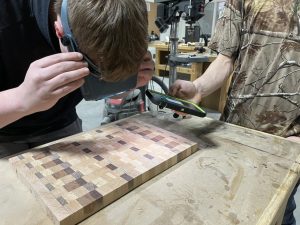 Examining a cutting board for scratches before applying finish.
